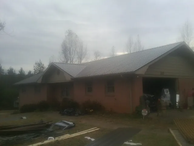 Gray metal roof on a stucco house with an attached garage in Garrison
